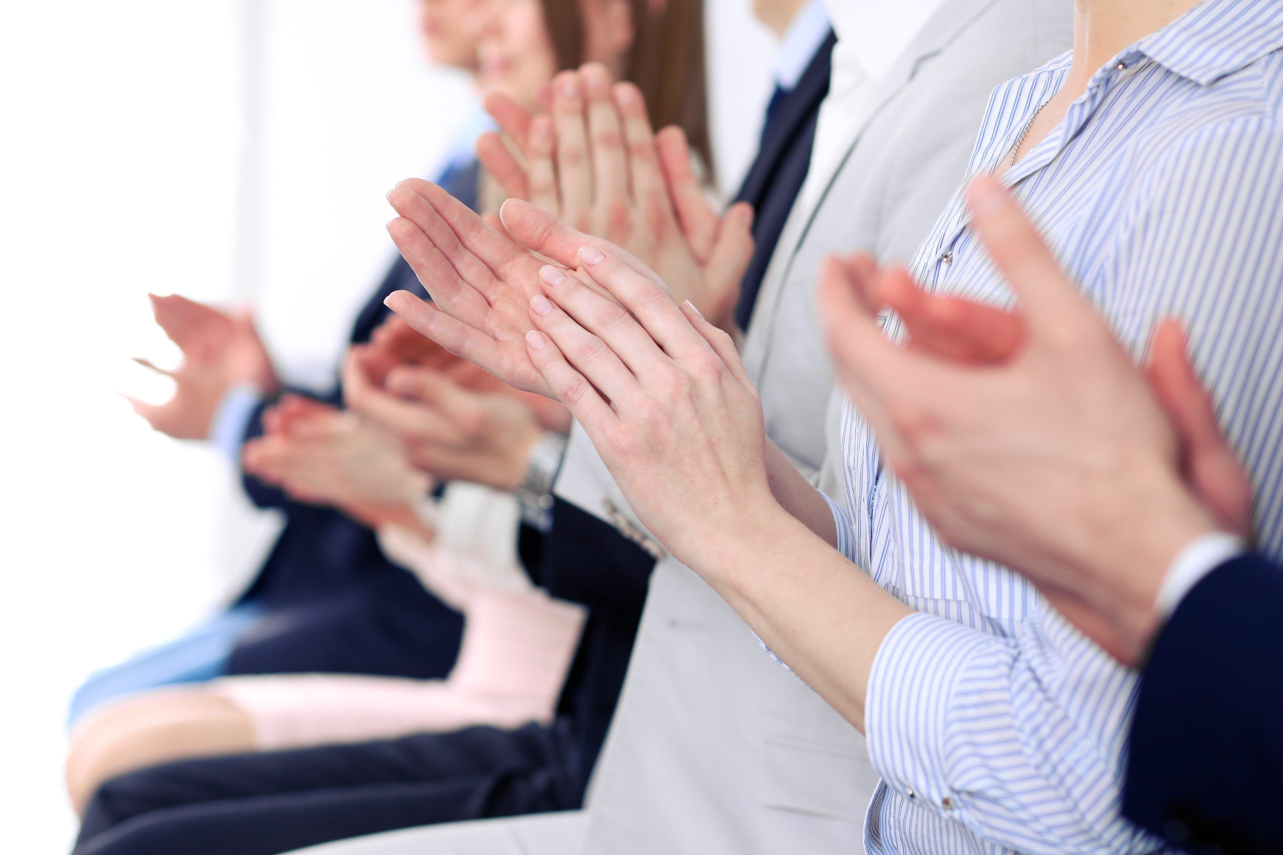 Close up of business people hands clapping at conference
