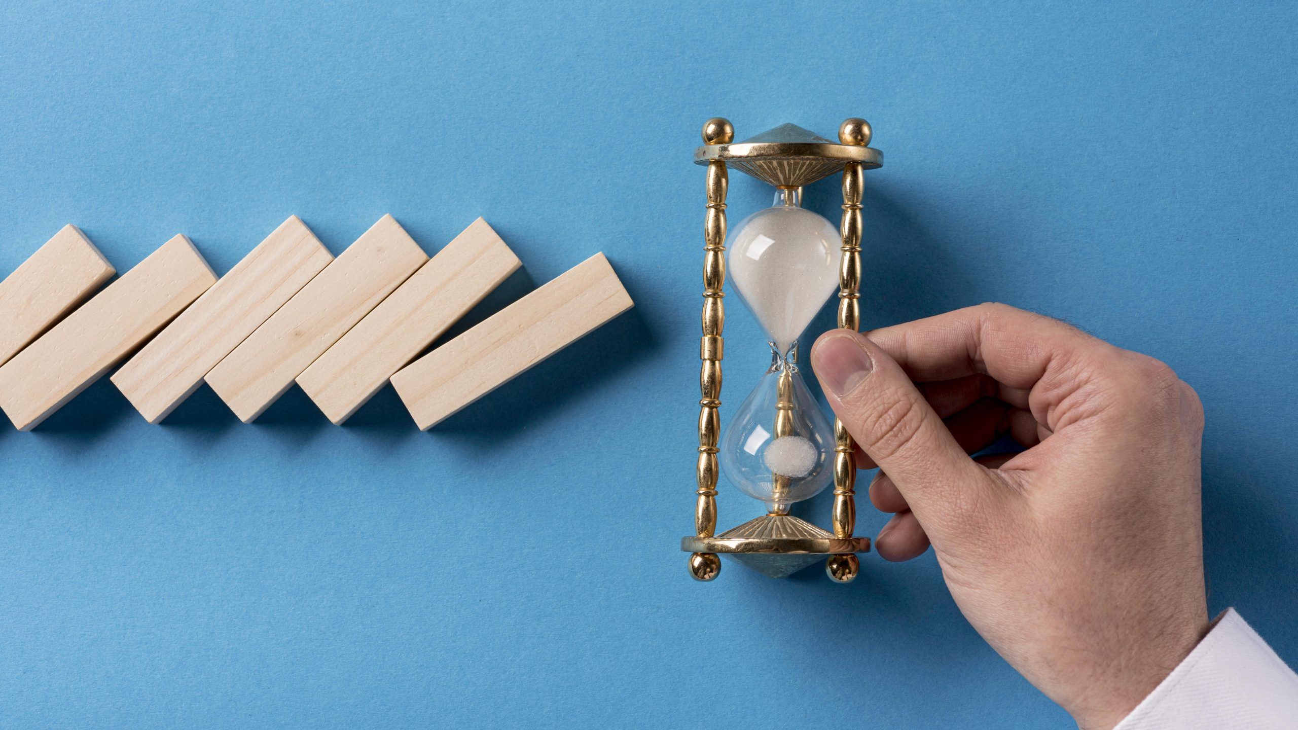 top-view-domino-pieces-with-businessman-holding-hourglass